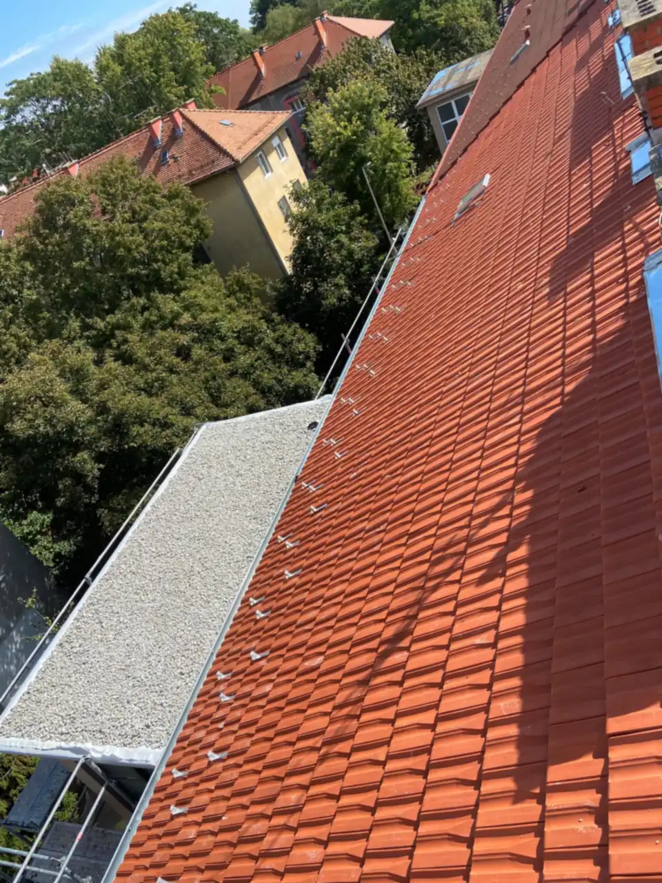 Novi glineni crijep sa snjegobranima uz ravni krov sa šljunkom u Zagrebu